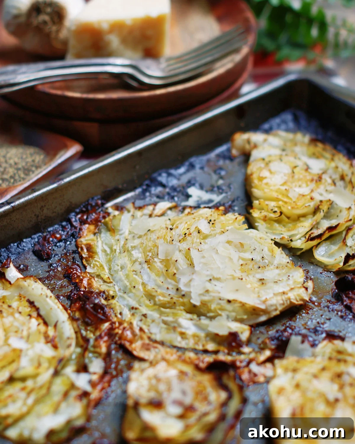 beef flavored roasted cabbage steaks on a sheet pan with parmesan cheese