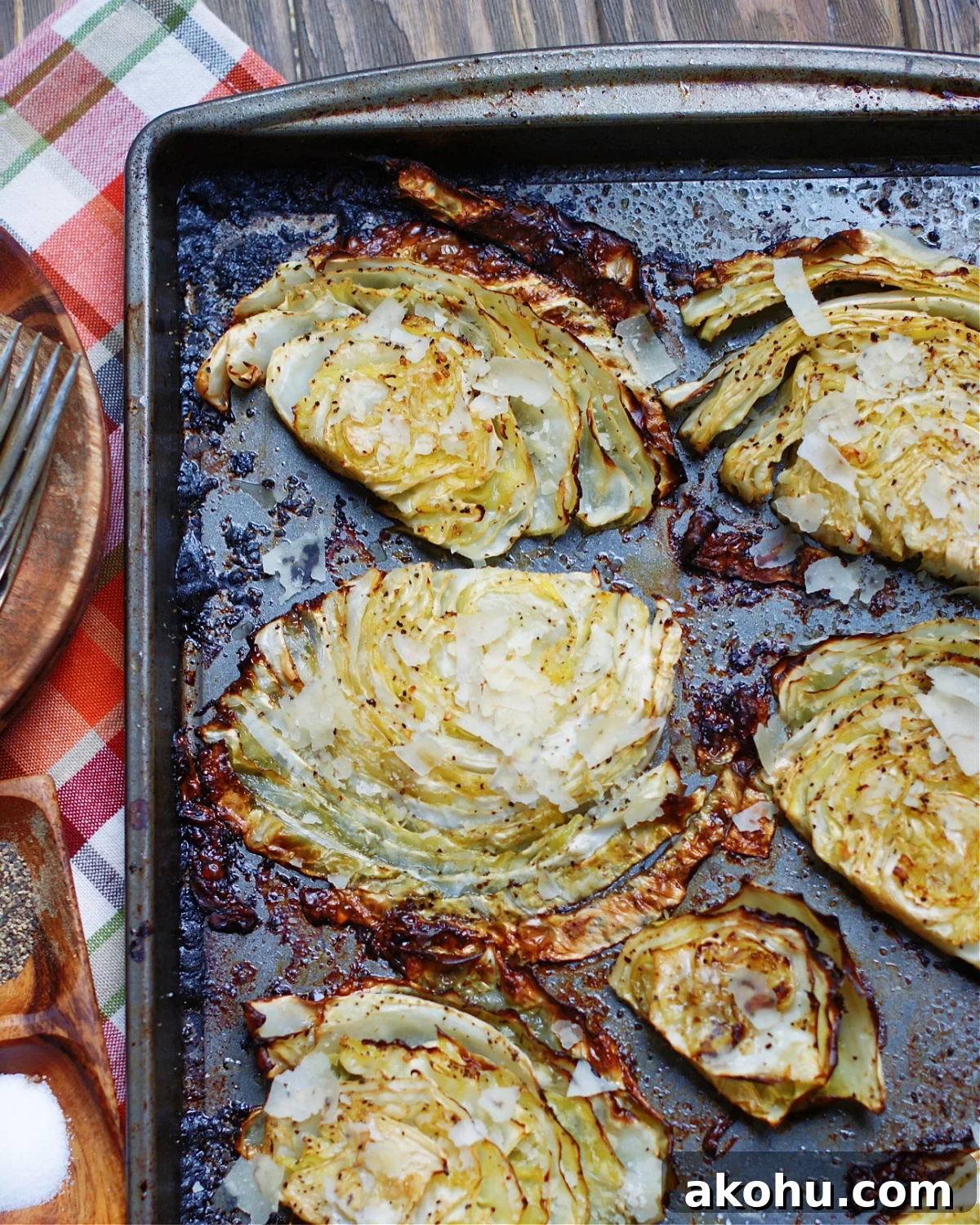 a finished pan of roasted cabbage steaks from the oven with parmesan cheese