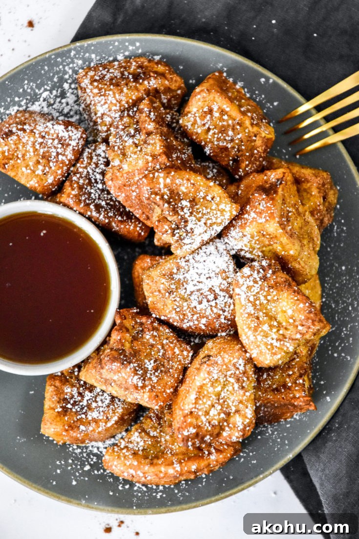 air fryer french toast bites on a plate with cup of syrup.