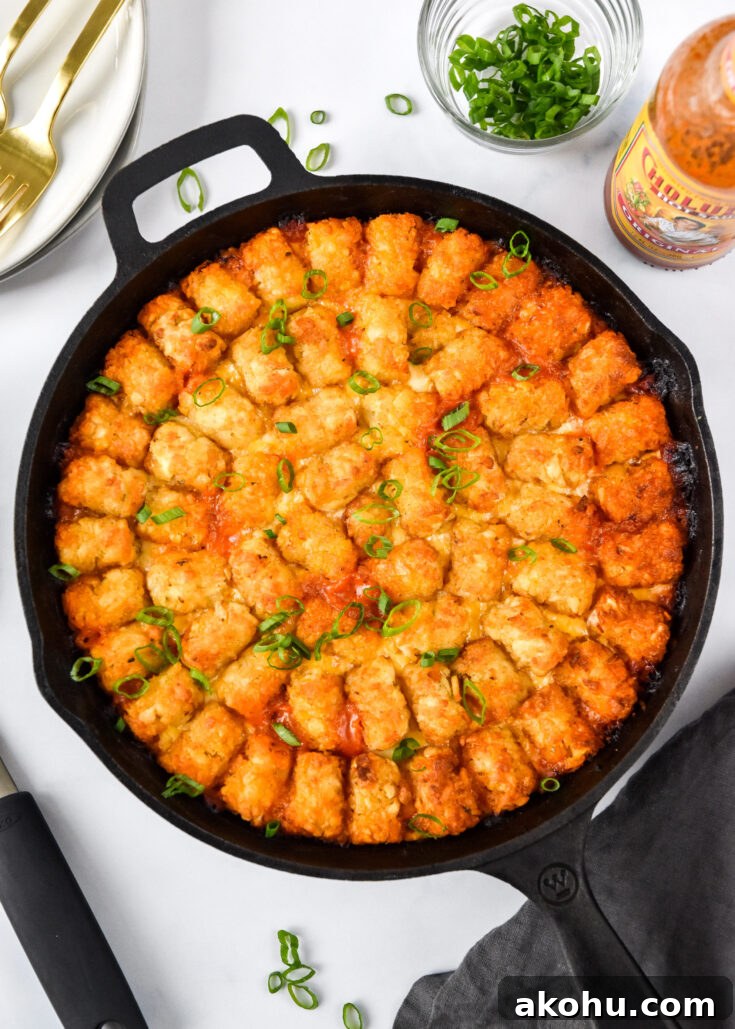 turkey sloppy joe tater tot casserole cooked in a cast iron on a table.