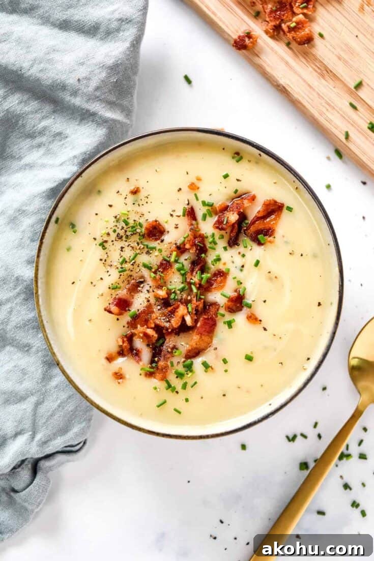 Creamy potato onion soup with bacon bits and chives on top.