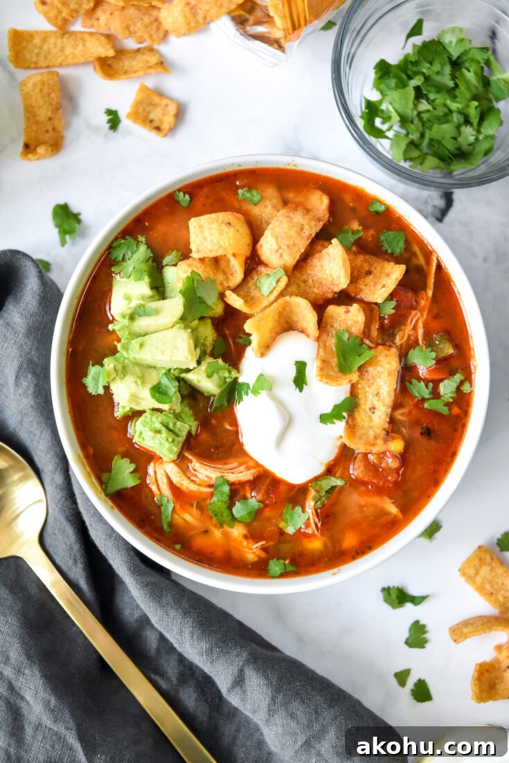 bowl of instant pot no bean chicken chili with sour cream, avocado and corn chips on top.