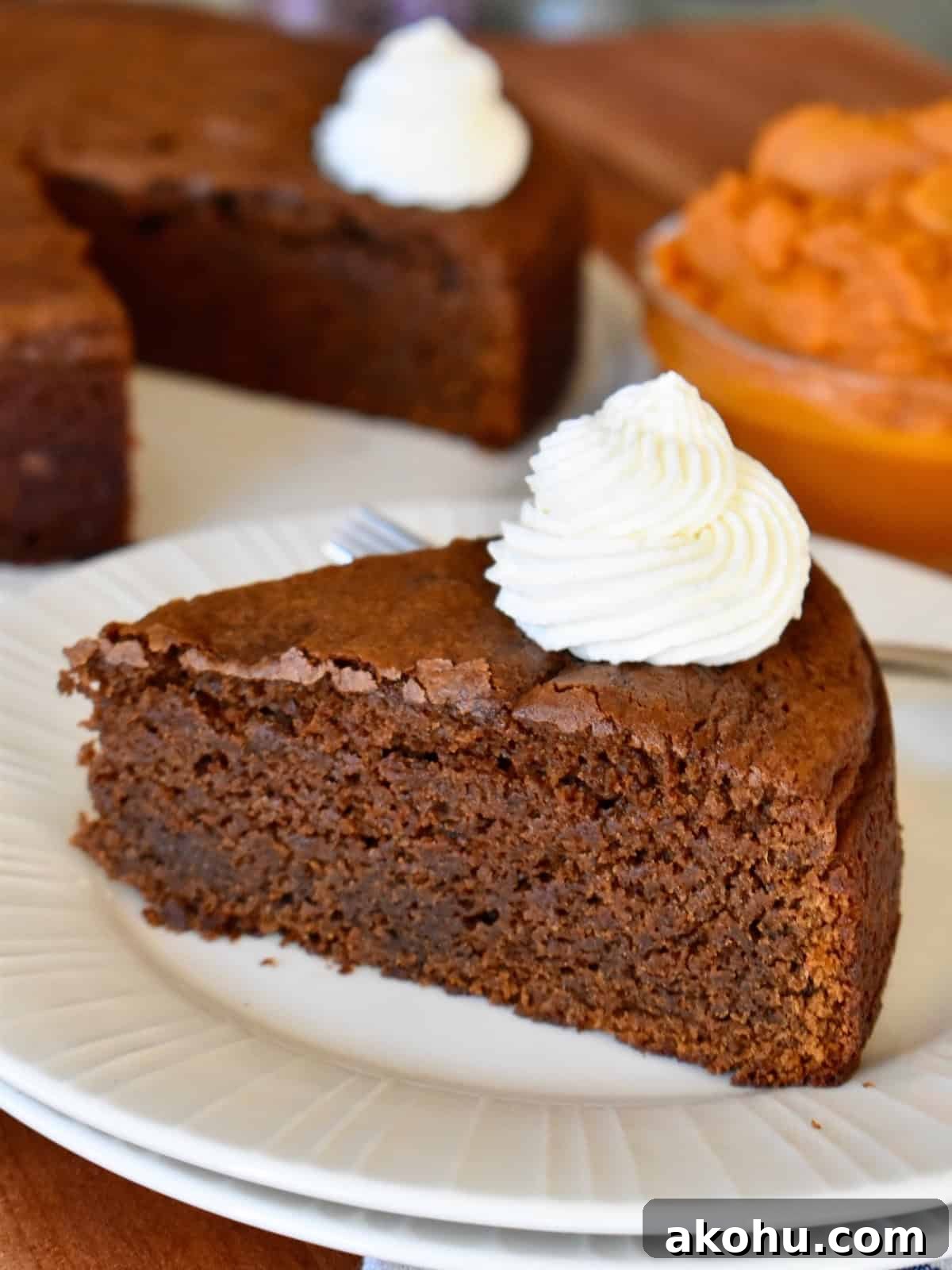 Moist Chocolate Pumpkin Cake Recipe – Simple Fall Dessert 2 Chocolate Pumpkin Cake with whipped cream on a white plate.