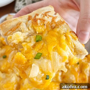Pierogi Pizza (Pagach) Recipe: Polish Dumpling-Style Pizza 8 hand holding slice of pierogi pizza (pagach) with cheddar cheese and onions