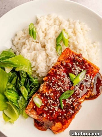 A bowl of rice, bok choy and teriyaki salmon.