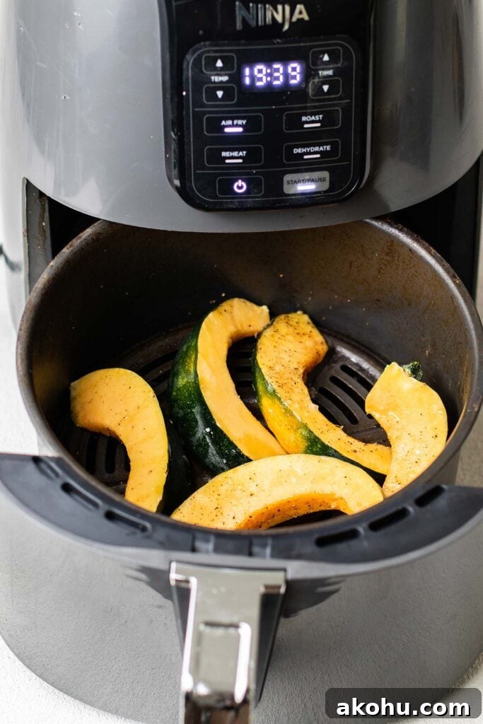 Crispy Air-Fryer Acorn Squash Recipe for Fall Sides 4 Slices of acorn squash in a Ninja Air Fryer.