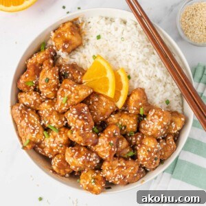 A bowl of crispy chicken in air fryer served with rice and chopsticks.