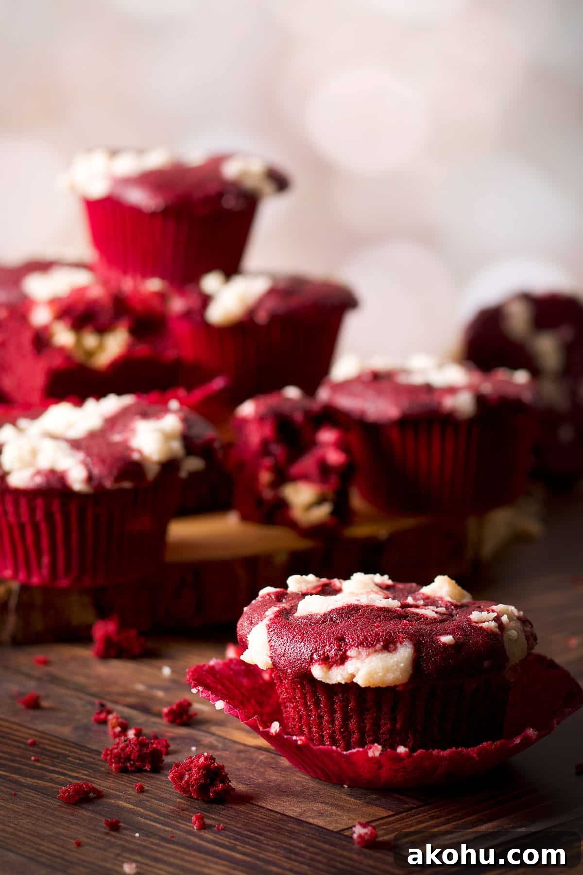 Red Velvet Muffins Filled with Cream Cheese Swirl 5 A cluster of red velvet muffins on stacked wooden serving boards.