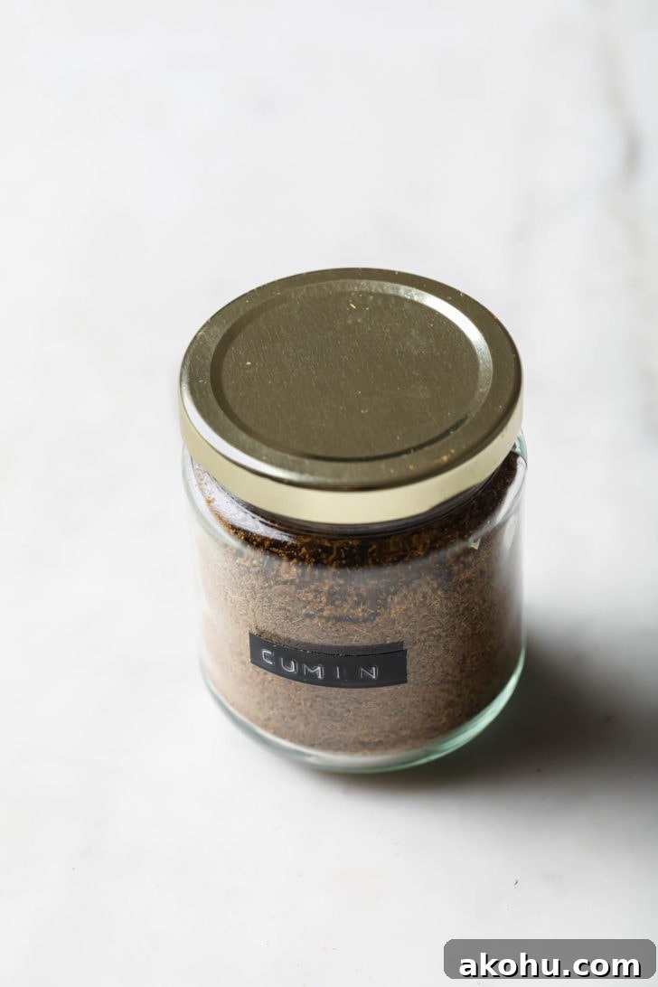 Cumin powder in a labeled, covered glass jar.
