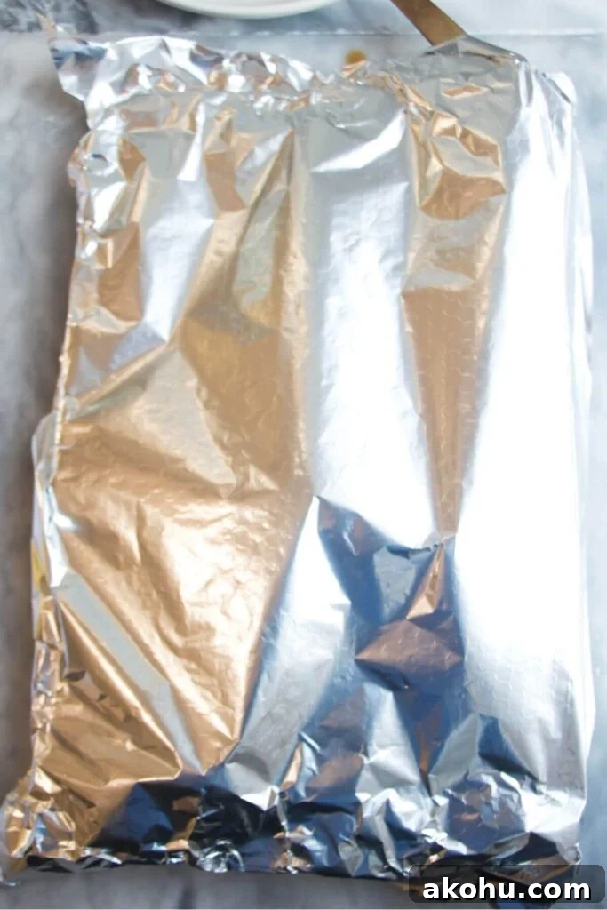 Foil covered oven tray with salmon fillet inside.