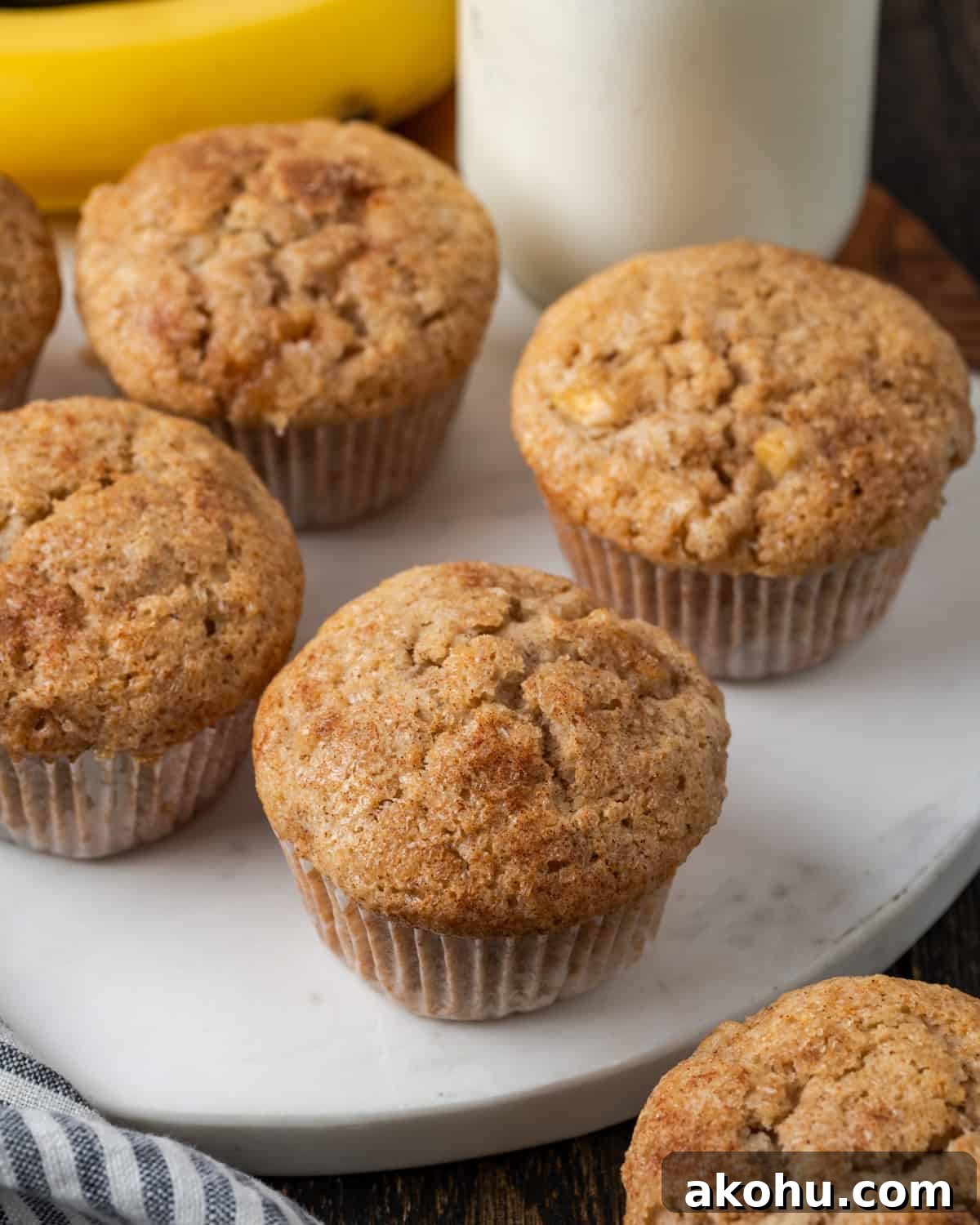 Apple Banana Muffins Recipe for Moist, Fluffy Bites 13 A batch of apple banana muffins sitting on a white marble cutting board.