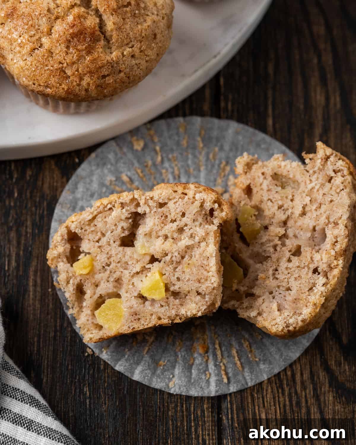 Apple Banana Muffins Recipe for Moist, Fluffy Bites 14 Two halves of a muffin on a table showing chunks of apples inside.
