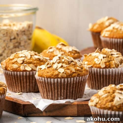 Several banana oat flour muffins sitting on a wooden tray.