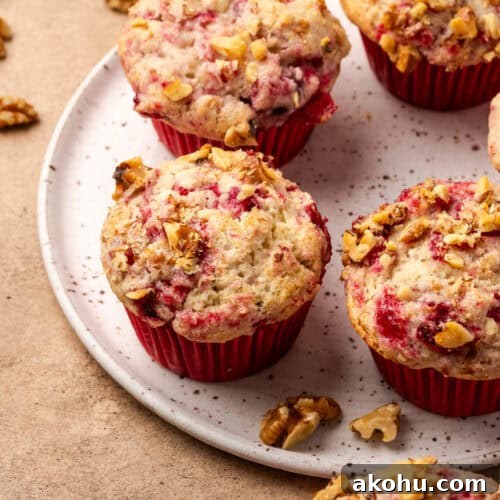 Several cranberry sauce muffins served on a ceramic plate.