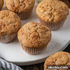 Apple Banana Muffins Recipe for Moist, Fluffy Bites 20 A batch of apple banana muffins sitting on a white marble cutting board.