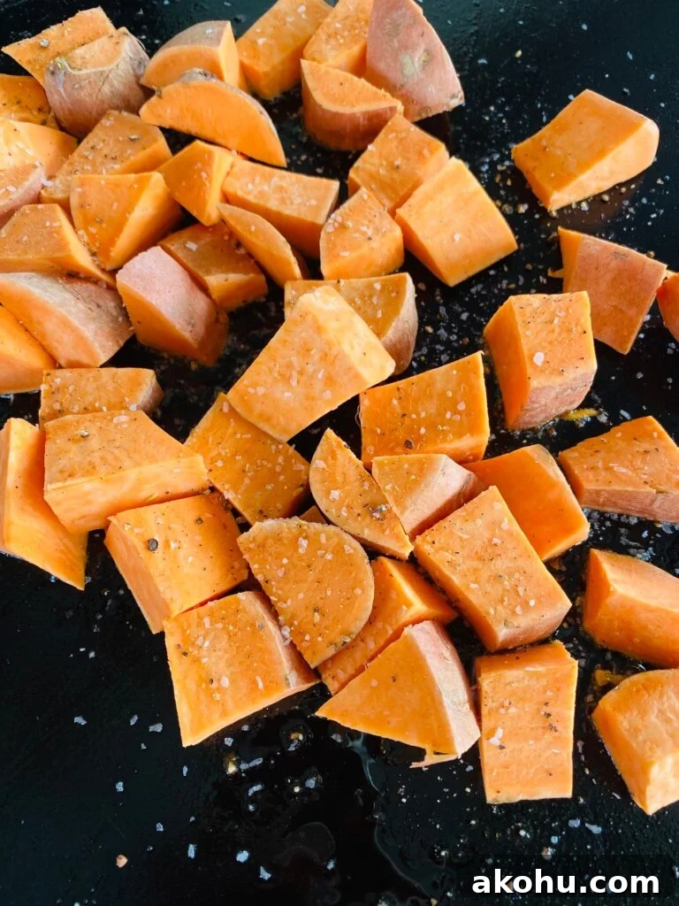 diced sweet potatoes on the griddle before cooking