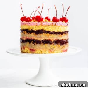 Banana split layer cake with layers of chocolate fudge filling and banana, and maraschino cherries on a white cake stand.