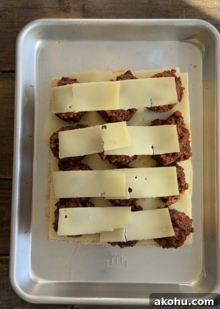 Savory Sloppy Joe Sliders with Tangy BBQ Sauce 7 cheese layered on top of sloppy joe sliders