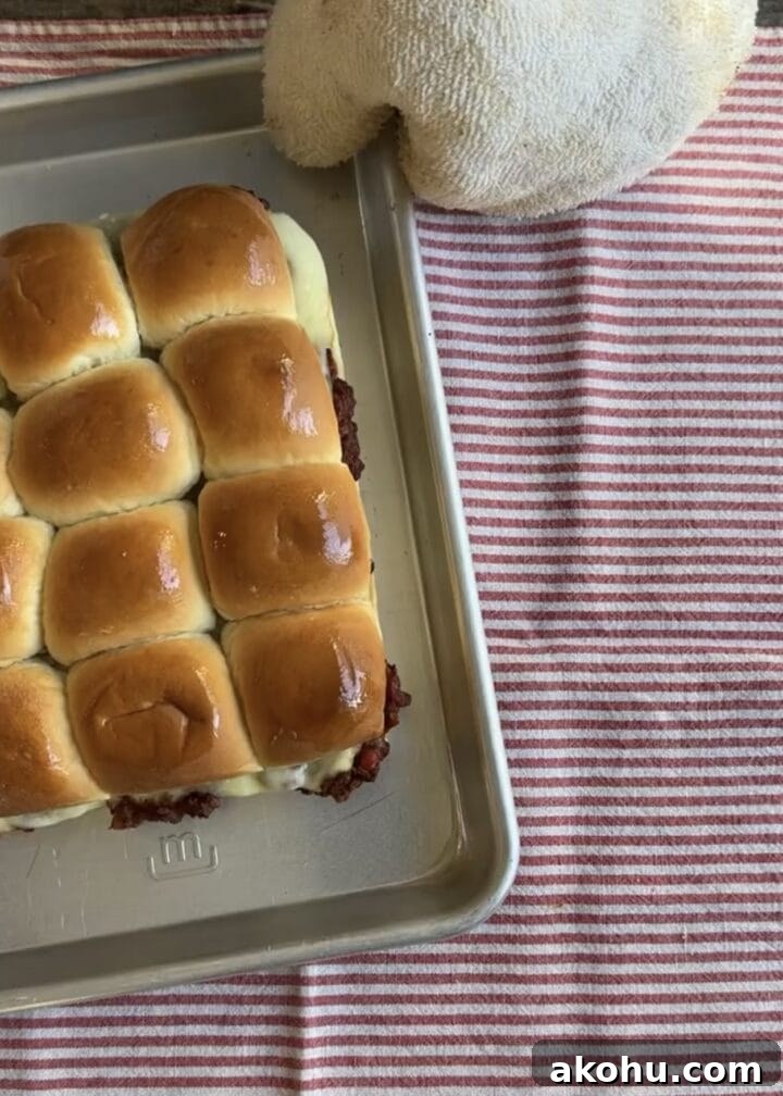 Savory Sloppy Joe Sliders with Tangy BBQ Sauce 8 sloppy joe sliders on a baking tray on a red and white striped napkin
