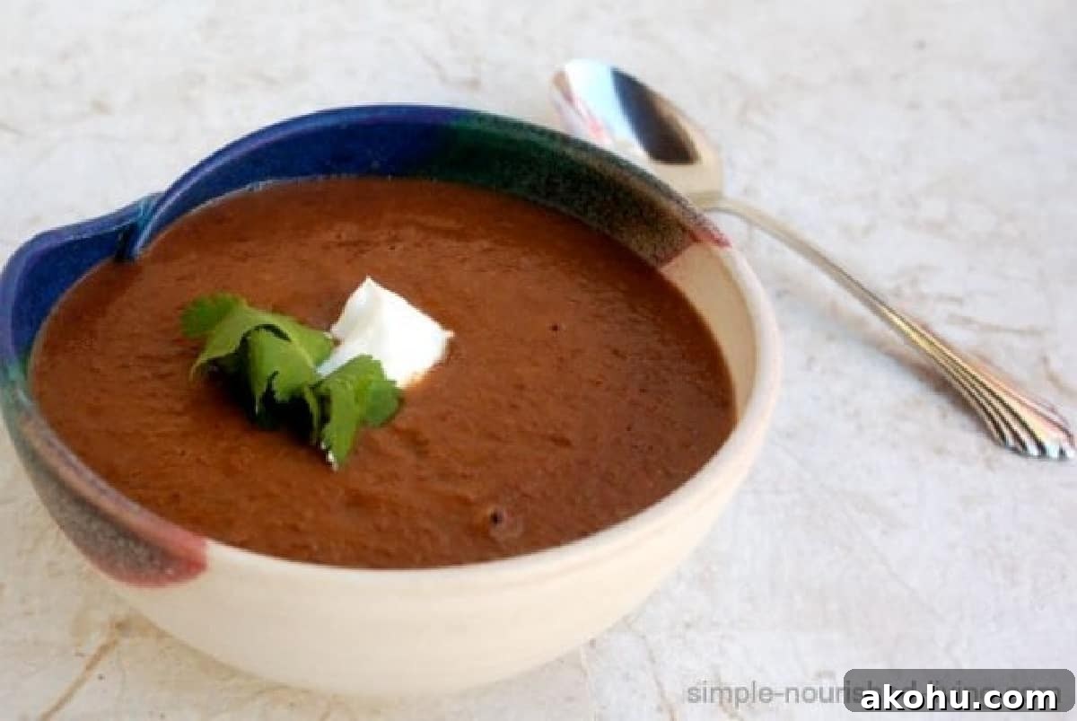 Bowl of black bean soup garnished with fresh cilantro and dollop of Greek yogurt.