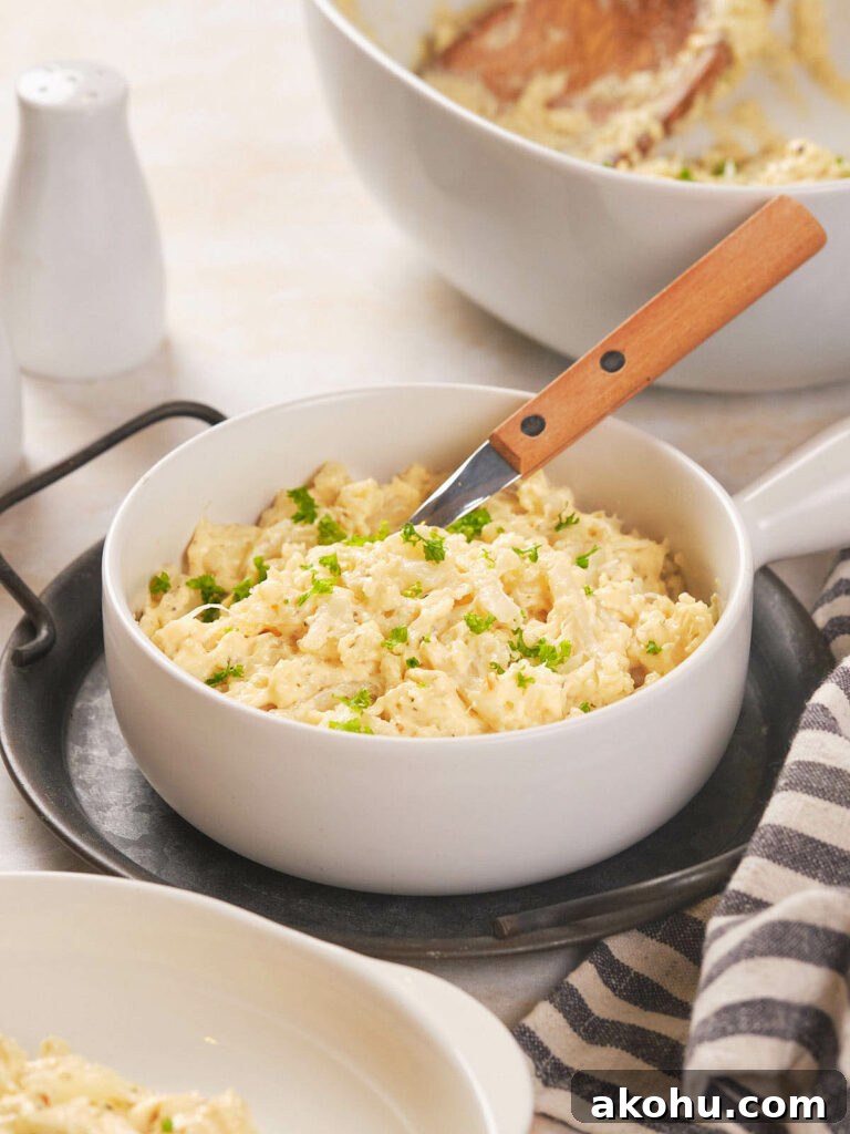 Keto Cauliflower Mac and Cheese: 4-Step Low-Carb Recipe 2 A white bowl filled with scrambled cauliflower garnished with chopped herbs.