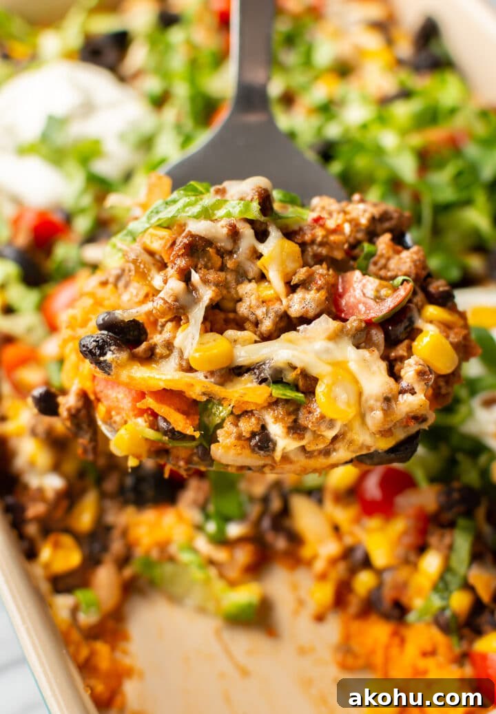 Cheesy Taco Casserole with Beef and Crispy Tortilla Topping 2 close-up of taco casserole on a metal spatula
