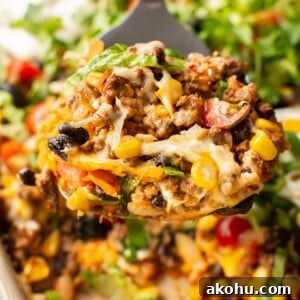 Cheesy Taco Casserole with Beef and Crispy Tortilla Topping 9 close-up of taco casserole on a metal spatula