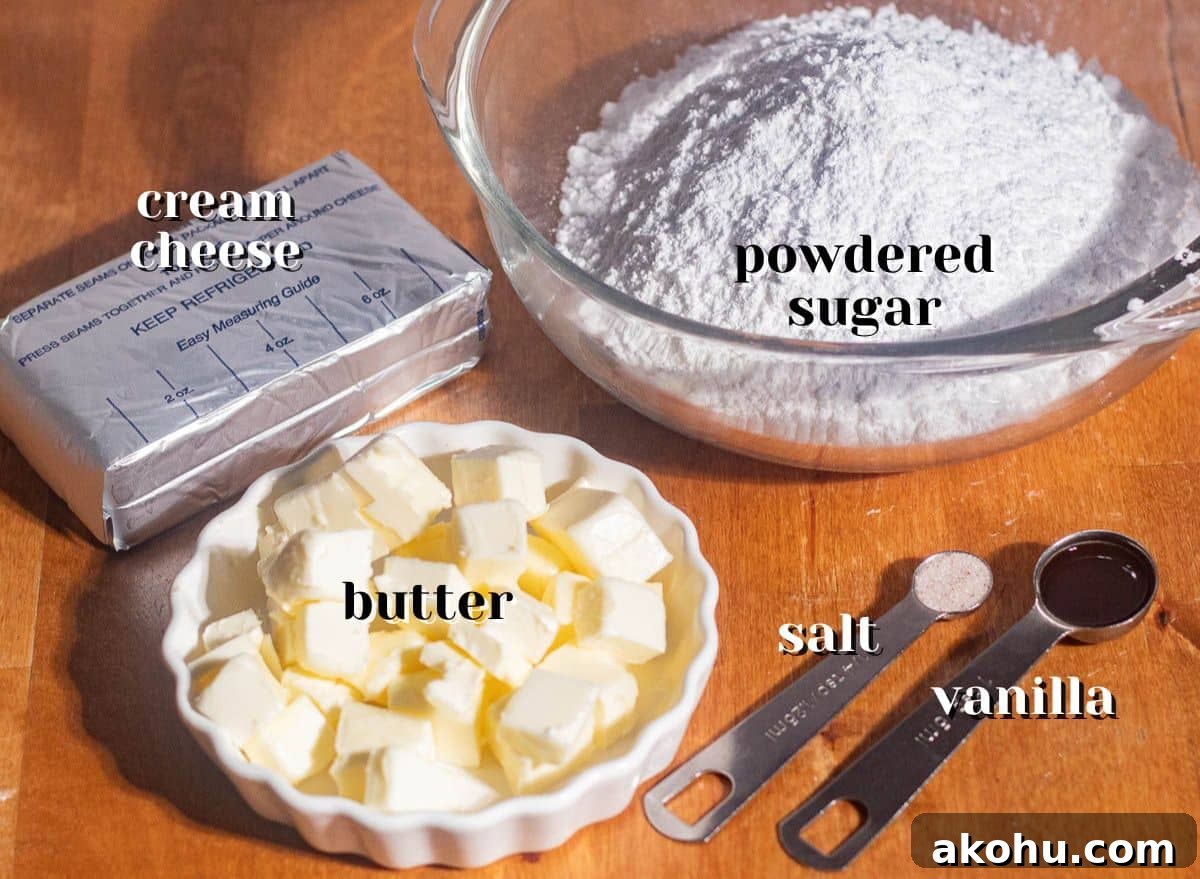 Measured ingredients for browned butter cream cheese frosting including butter cubes, powdered sugar, cream cheese, vanilla extract, and salt.