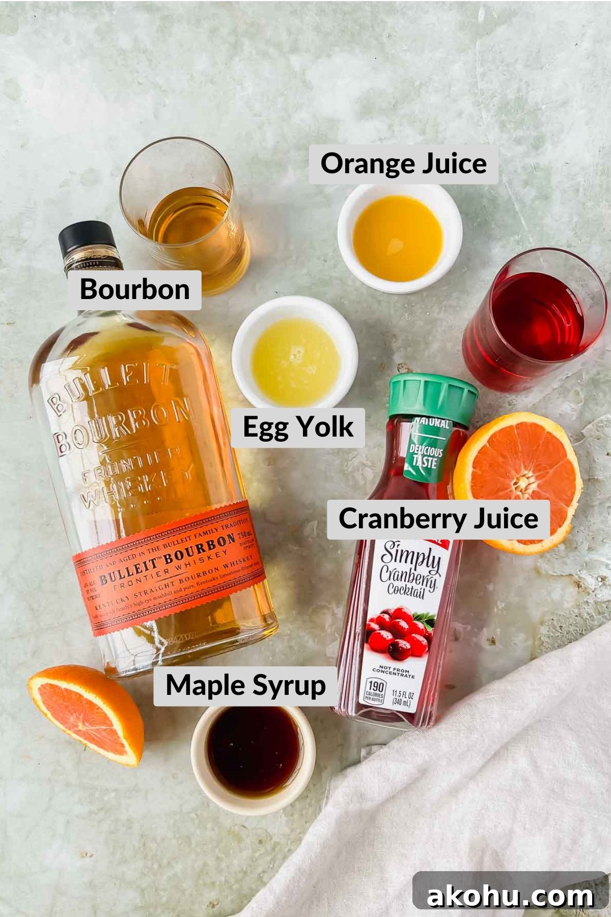 ingredients for cranberry whiskey sour on green background.