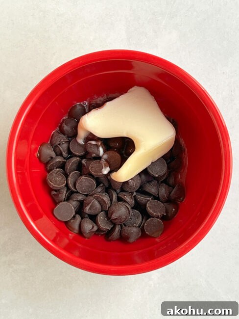 Chocolate and butter in red bowl after first microwave to start the melting.