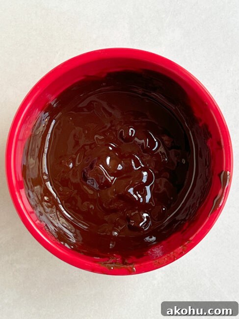 Chocolate and butter mixed in red bowl.
