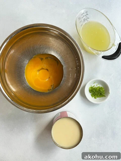 Filling ingredients for key lime mini pies including egg yolks, lime juice and zest and sweetened condensed milk.