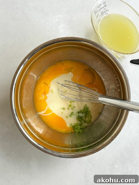 Sweetened condensed milk and lime zest added to egg yolks.