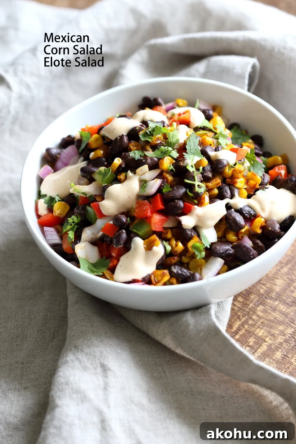 Mexican street corn salad in a white bowl with grey napkin