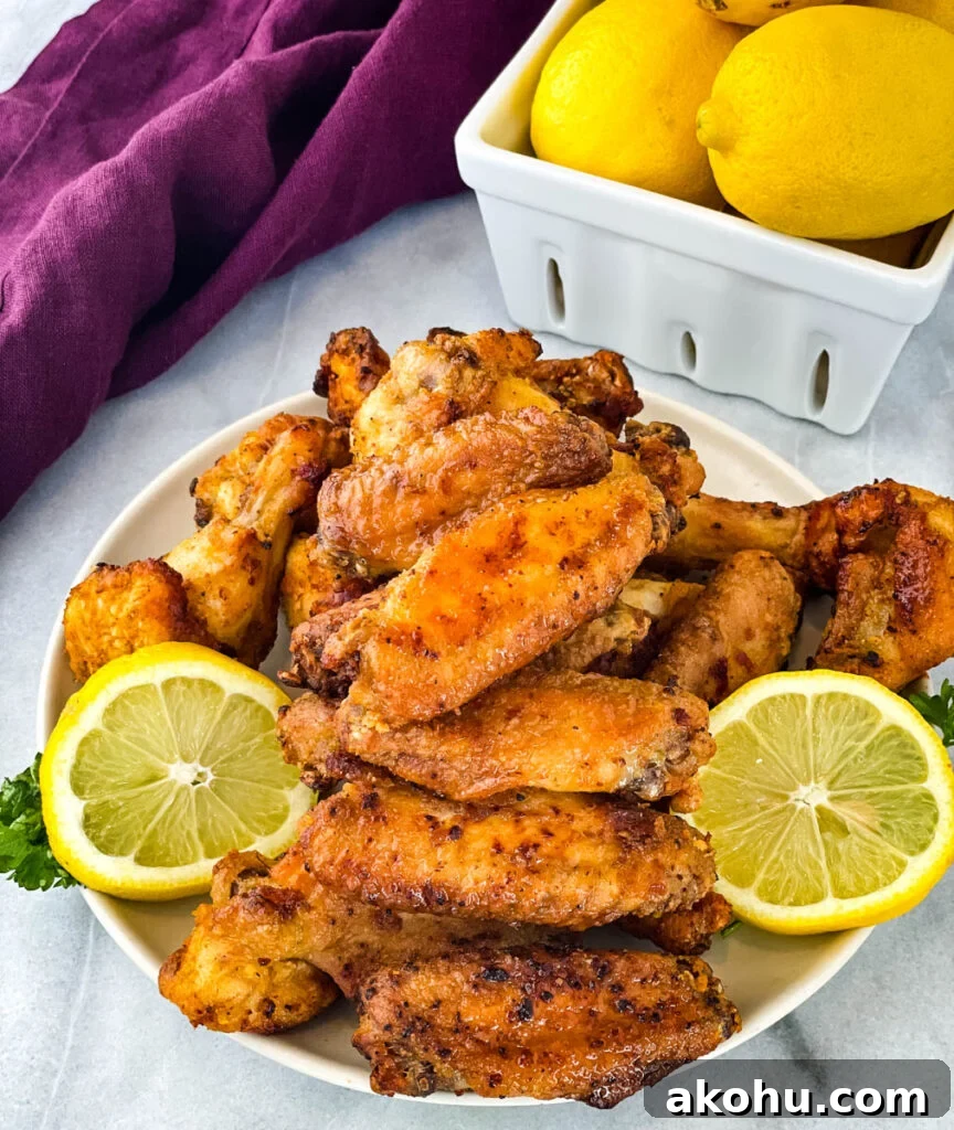lemon pepper chicken wings on a plate with lemons