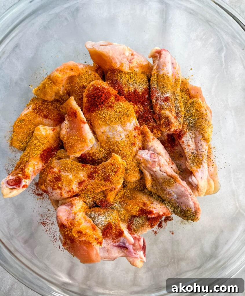 raw seasoned wings in a glass bowl