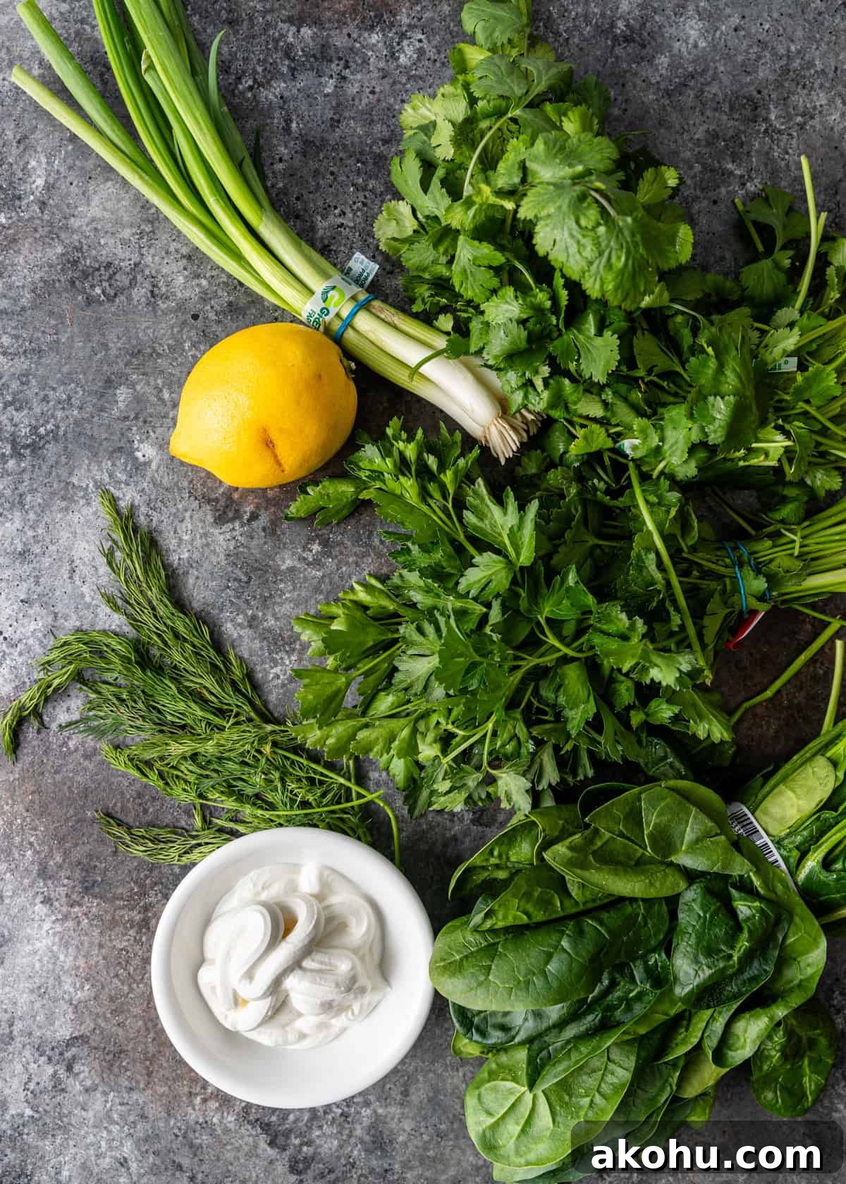 overhead: fresh herbs, cheese, lemon, and spinach for persian noodle soup