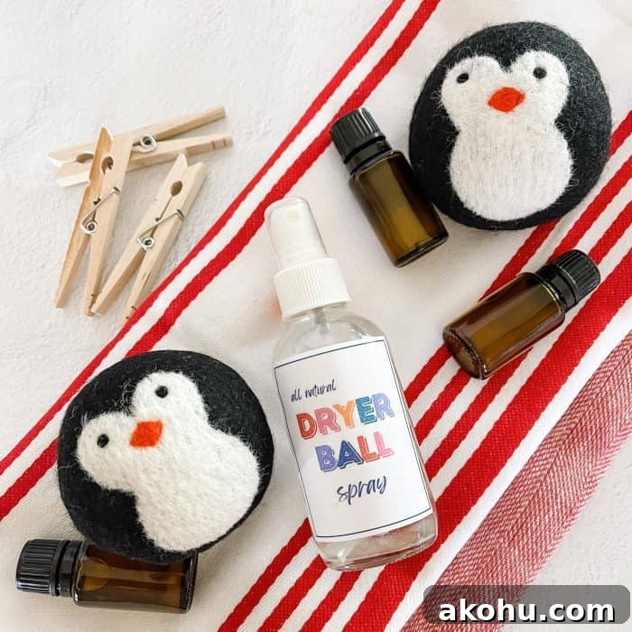 all natural dryer ball spray next to essential oil bottles, wool dryer balls, and clothes pins