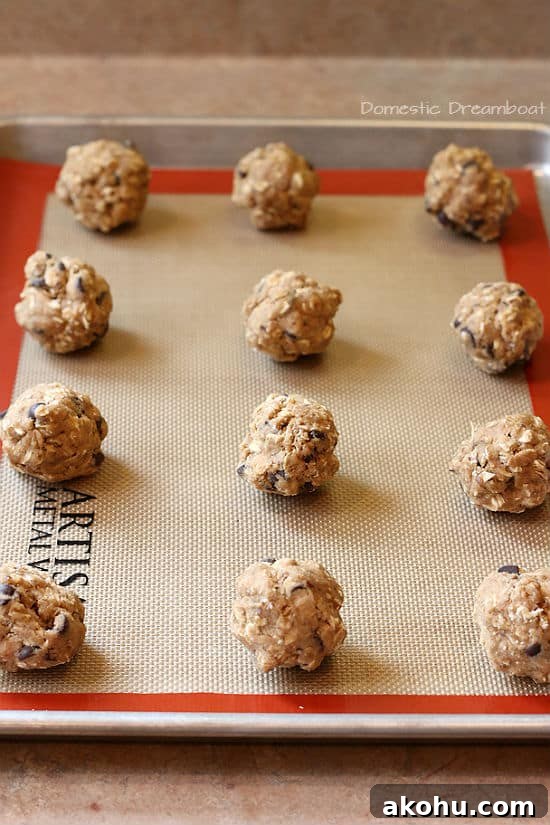 Oatmeal Chocolate Chip Cookies to Boost Milk Supply 4 Unbaked Oatmeal Chocolate Chip Lactation Cookies on a baking sheet.