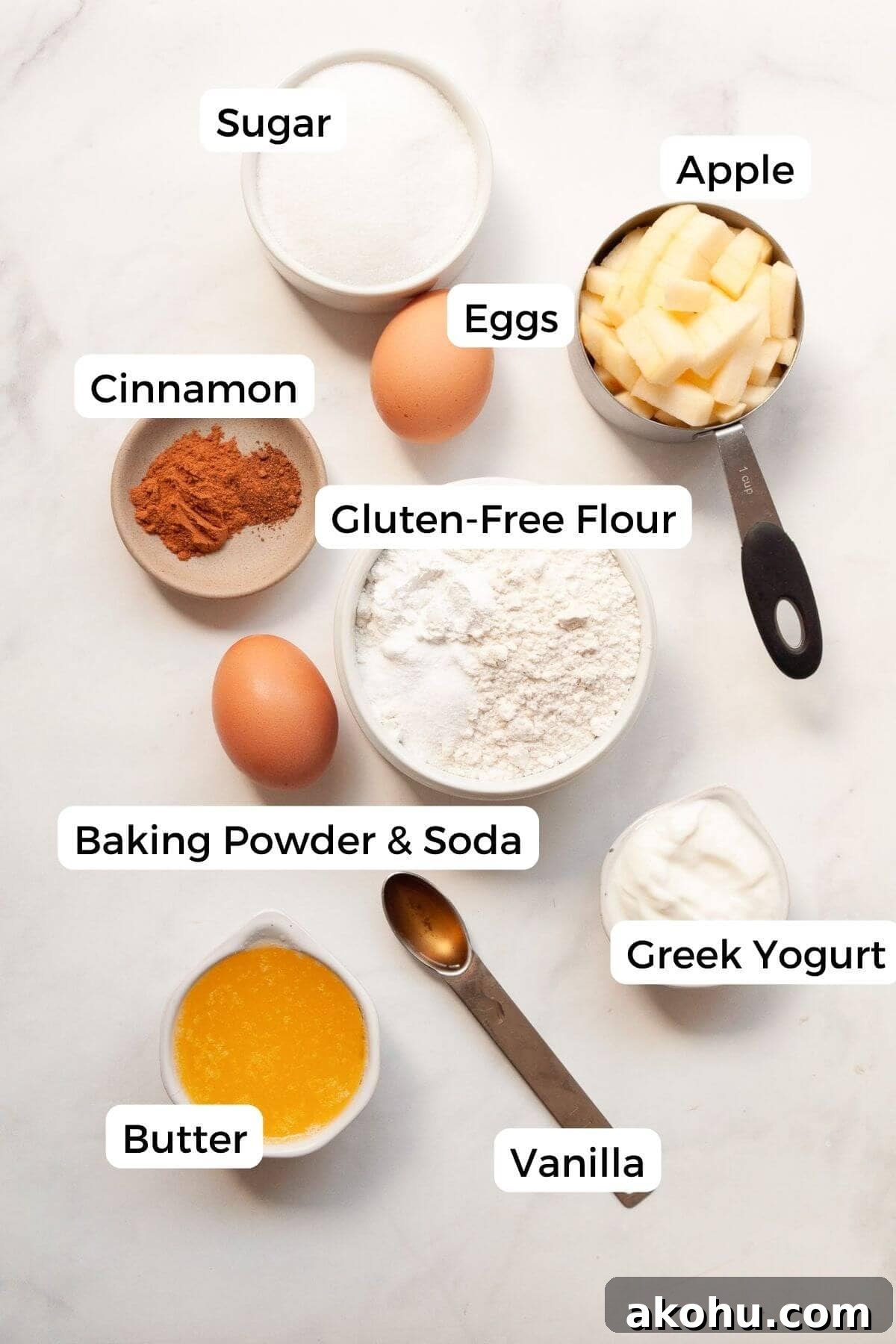 Gluten-Free Apple Cake: Moist Recipe with Cinnamon Crumble 3 All ingredients for gluten-free apple cake in small bowls, including fresh apples, gluten-free flour blend, Greek yogurt, butter, eggs, sugar, cinnamon, nutmeg, and vanilla.