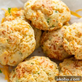 cheddar biscuits in a pile on crinkled parchment paper