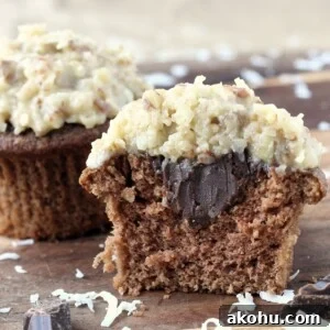 Split German chocolate cupcake showing soft, airy chocolate crumb inside.
