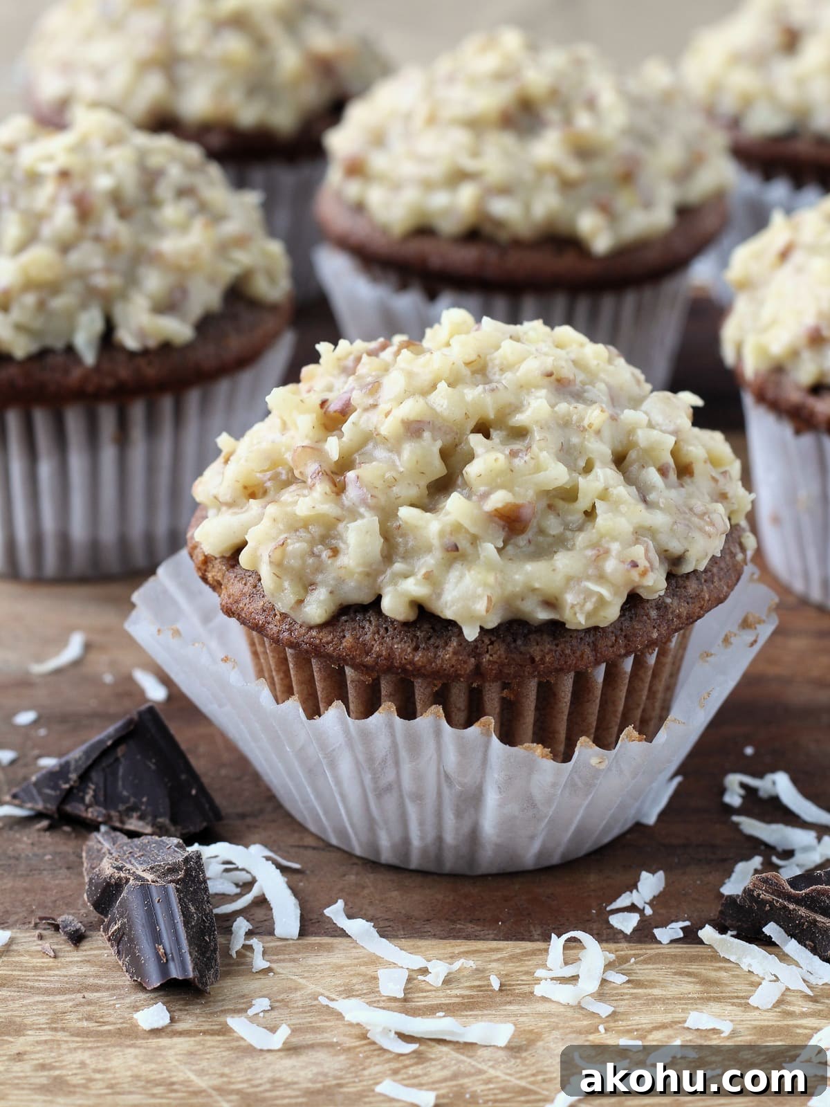 Decadent German Chocolate Cupcakes with Coconut-Pecan Frosting 5 Piece of Baker’s German chocolate resting beside frosted cupcakes.