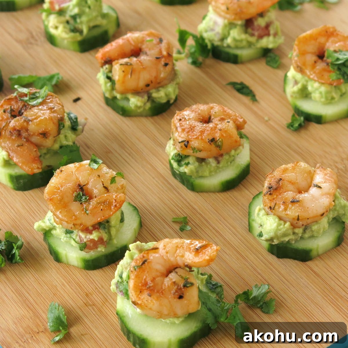 Cajun Shrimp Guacamole Bites on Cucumber rounds on serving board.