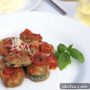 Baked Eggplant in Fresh Basil Marinara Sauce 12 A plate of food with baked eggplant.