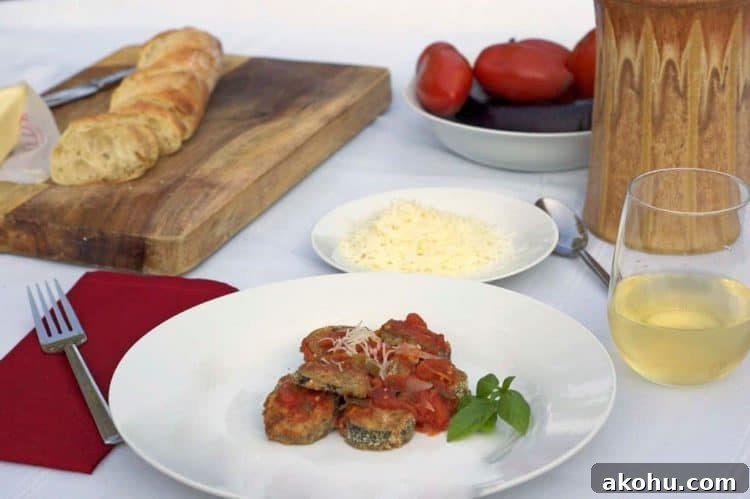 Baked Eggplant in Fresh Basil Marinara Sauce 9 A plate of food on a table with a loaf of bread