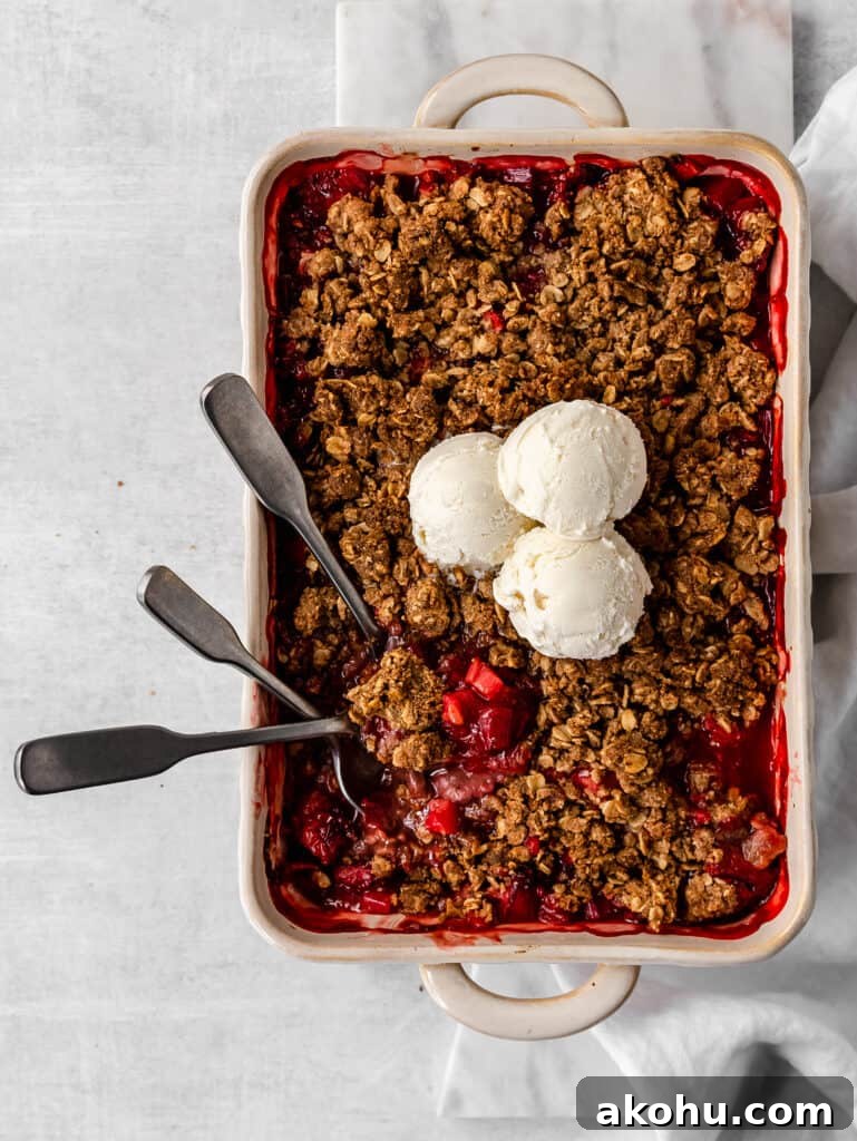 warm strawberry rhubarb crisp topped with cold ice cream 