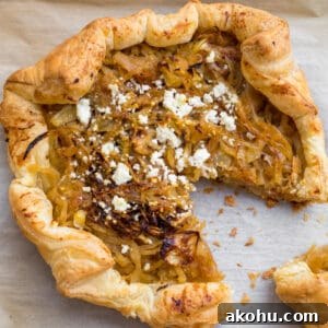 caramelized onion and goat cheese tart with a slice cut out of it