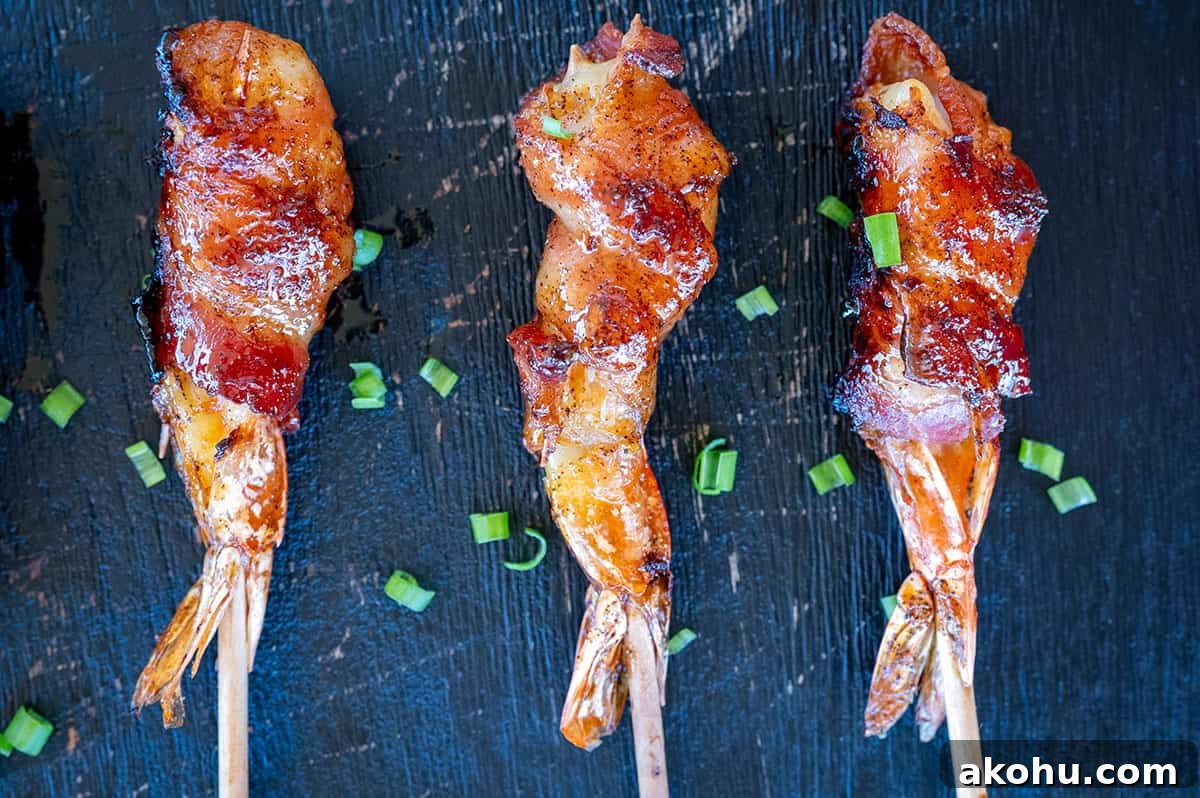 3 skewered bacon-wrapped shrimp on a platter.