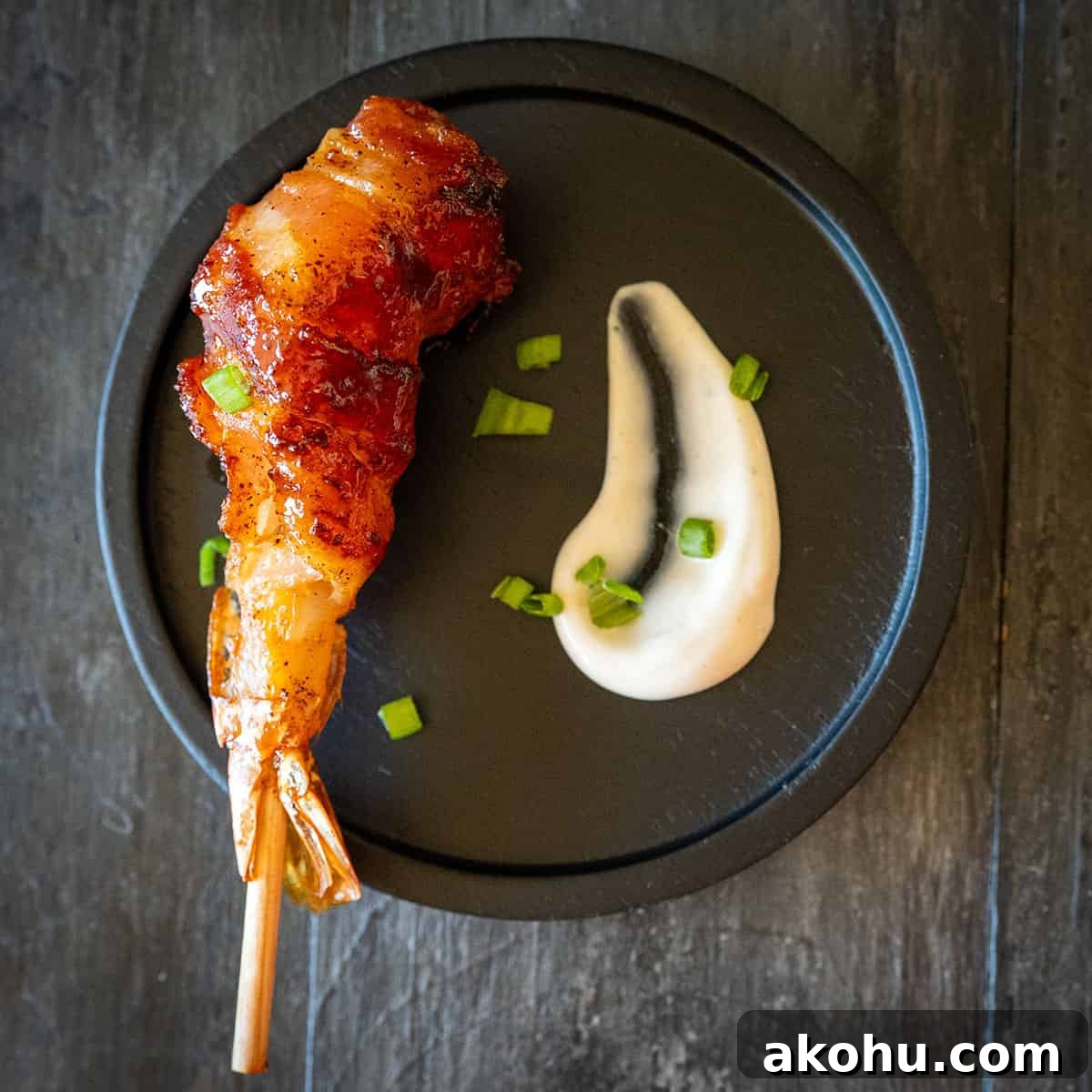bacon wrapped shrimp on plate with aioli.